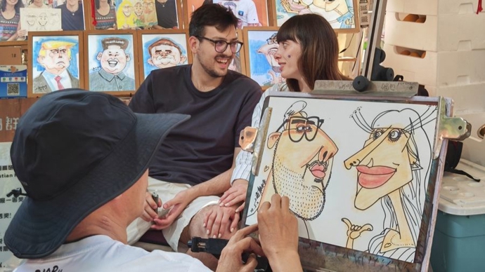 今年“五一”，意大利游客在静安寺公园的集市上体验街头画像。 &nbsp;李宝花 摄