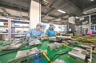 在位于京津中关村科技城的天津新松智能科技有限公司,工作人员对电子元器件进行检测。新华社发