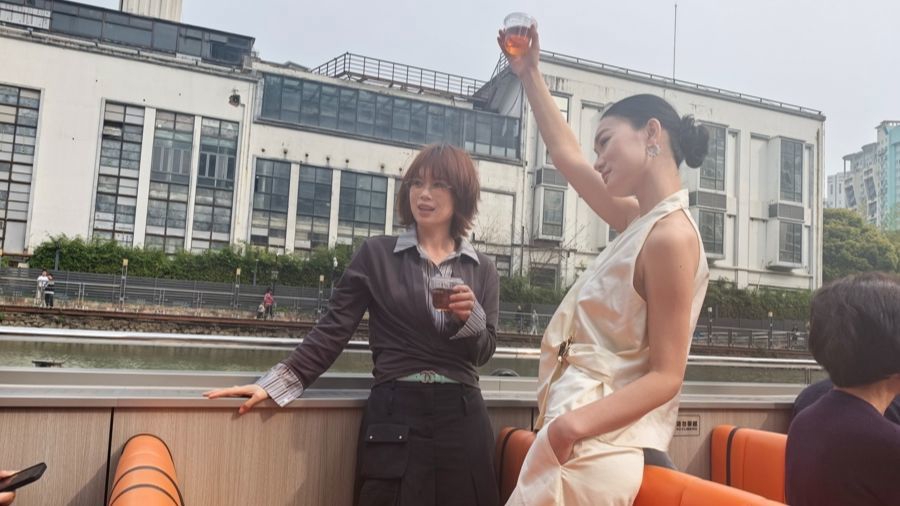 游客在苏州河游船上享受春日风景。