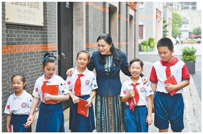 卢湾一中心小学校长吴蓉瑾与红领巾讲解员们在中共一大会址前。<BR/>卢湾一中心小学供图