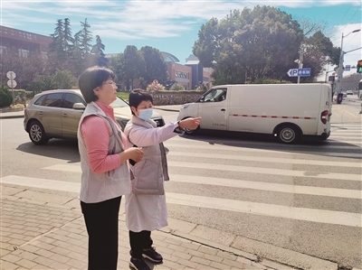 2023年2月,落组淞南镇政协委员工作站的戴红梅委员(右)在长江路、卫生科路路口调研交通信号灯时长设置情况