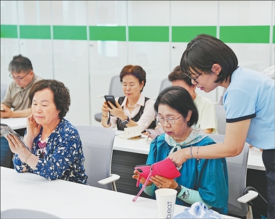 韩国首尔市区一家综合社会福利中心内,工作人员正指导老年人使用人工智能工具制作个性化健康食谱。<BR/>人民日报记者 汪思源摄
