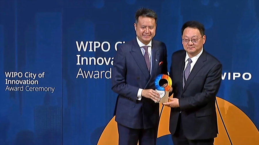 上海市政府副秘书长周亚明(右)从世界知识产权组织(WIPO)总干事邓鸿森手中接过创新城市奖杯。