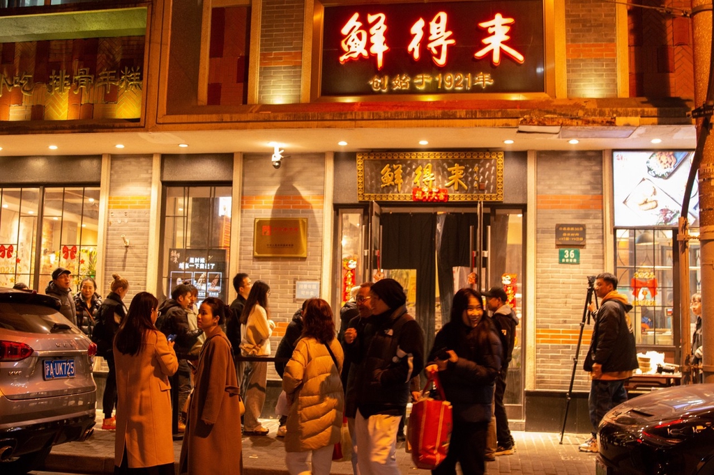 2024年1月15日，上海，夜幕降临，百年老字号鲜得来门口依旧排长队，食客络绎不绝只为等一客排骨年糕。