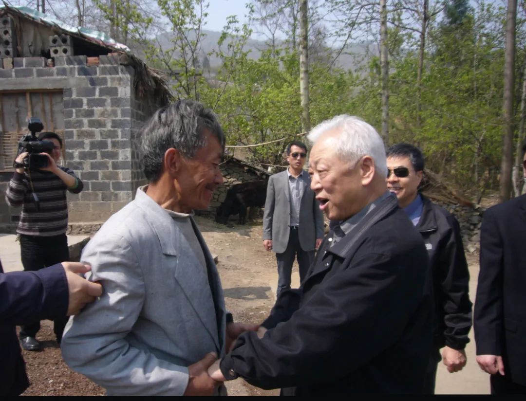 2009年3月,周铁农(前排右一)在民革中央新世纪重点扶贫联系村——贵州省毕节市纳雍县核桃寨村慰问农户并与农户亲切交谈。