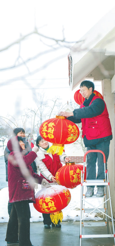 江苏省宿迁市,志愿者在帮当地村民挂灯笼。徐江海摄(影像中国)